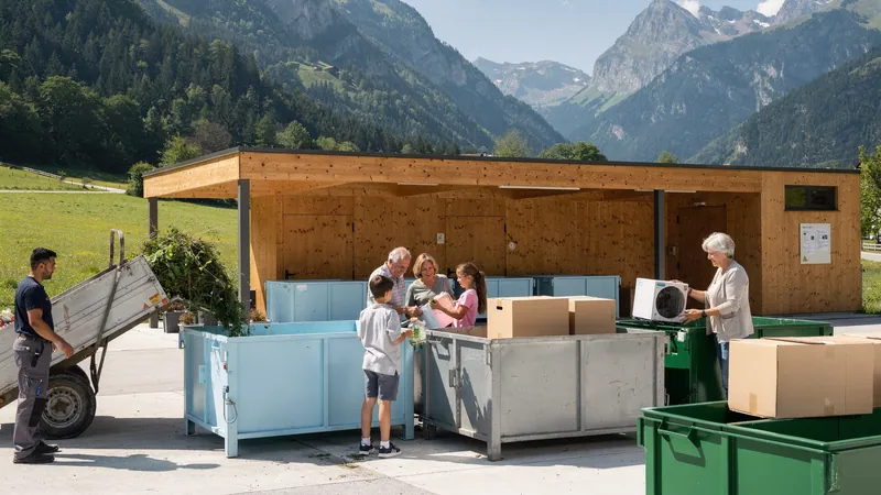 Eine Familie und weitere Menschen geben in einem österreichischen Altstoffsammelzentrum im Alpental Grünschnitt, Karton und ein Elektrogerät ab.
